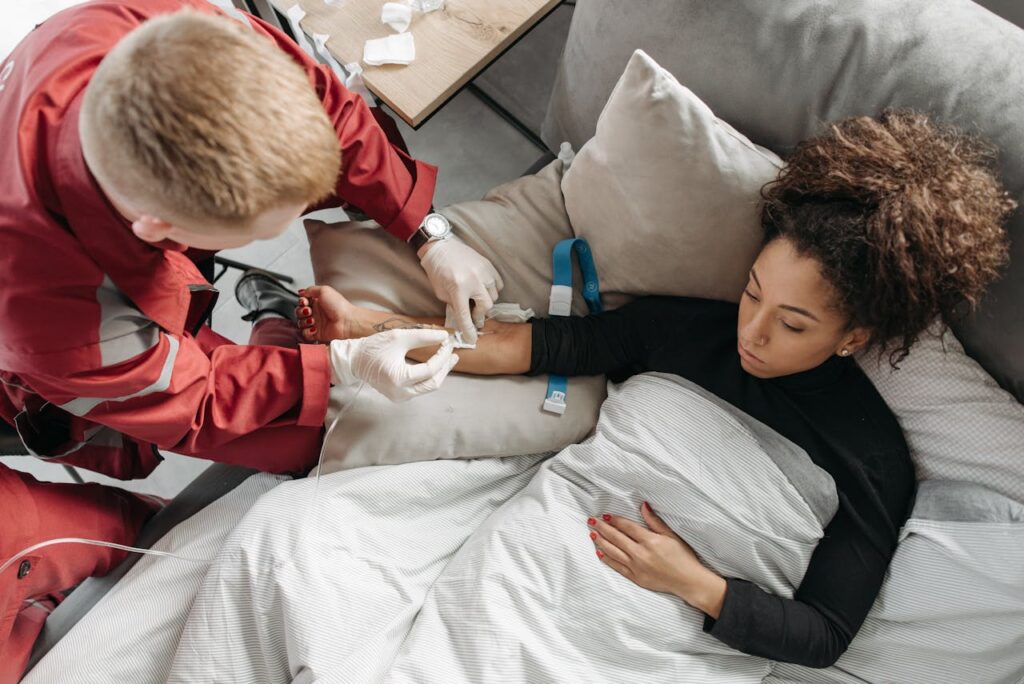 pexels photo 6753450 Paramedic tending to a woman at home, showcasing medical assistance in a personal setting.